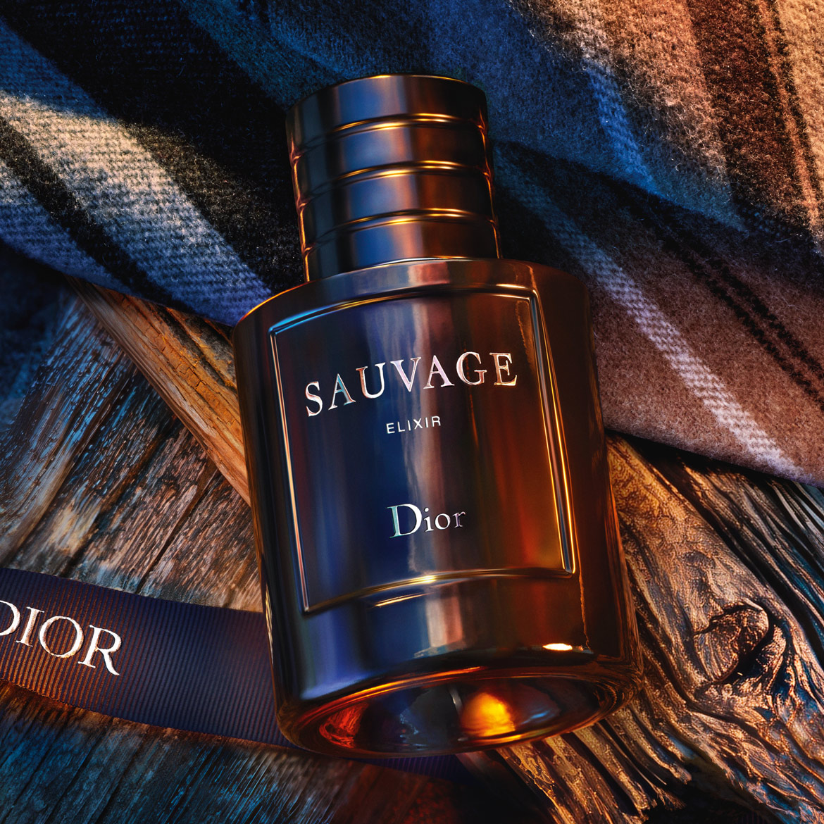 Découvrez Sauvage Elixir de Dior, un parfum intense dans un flacon élégant, posé sur du bois texturé et un tissu à carreaux, rehaussé d'un ruban portant le nom Dior.