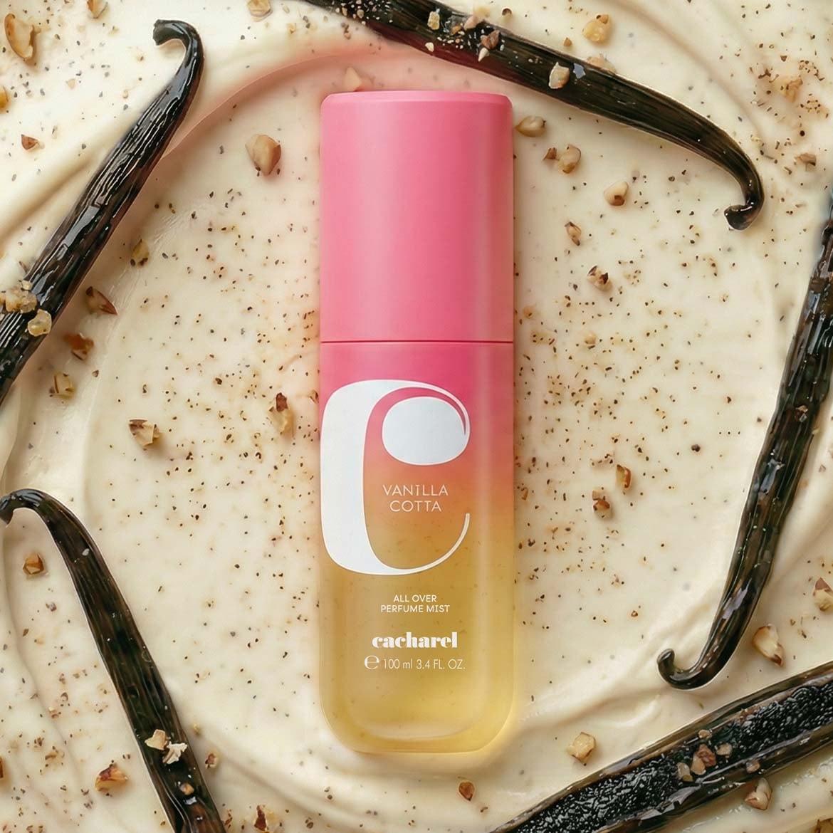 Le parfum Cacharel Vanilla Cotta, un vaporisateur de 100 ml, est présenté sur un fond crémeux parsemé de gousses de vanille et de noix concassées.