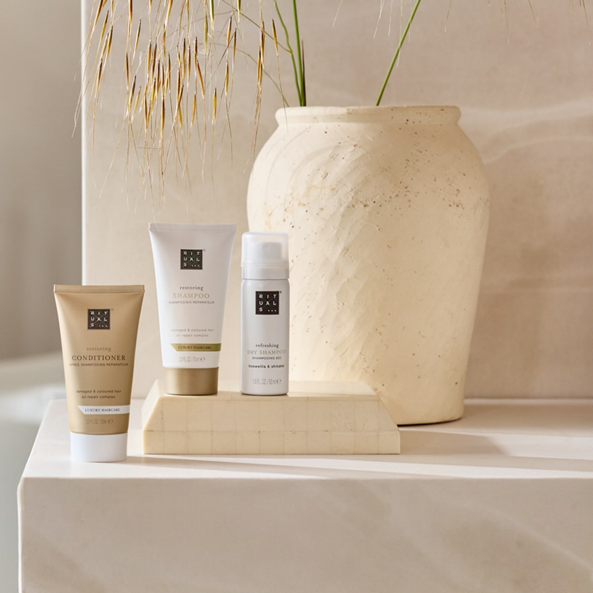 Découvrez le trio de soins capillaires Rituals : revitalisez vos cheveux avec le shampooing et l'après-shampooing réparateurs, puis rafraîchissez-les avec le shampooing sec.