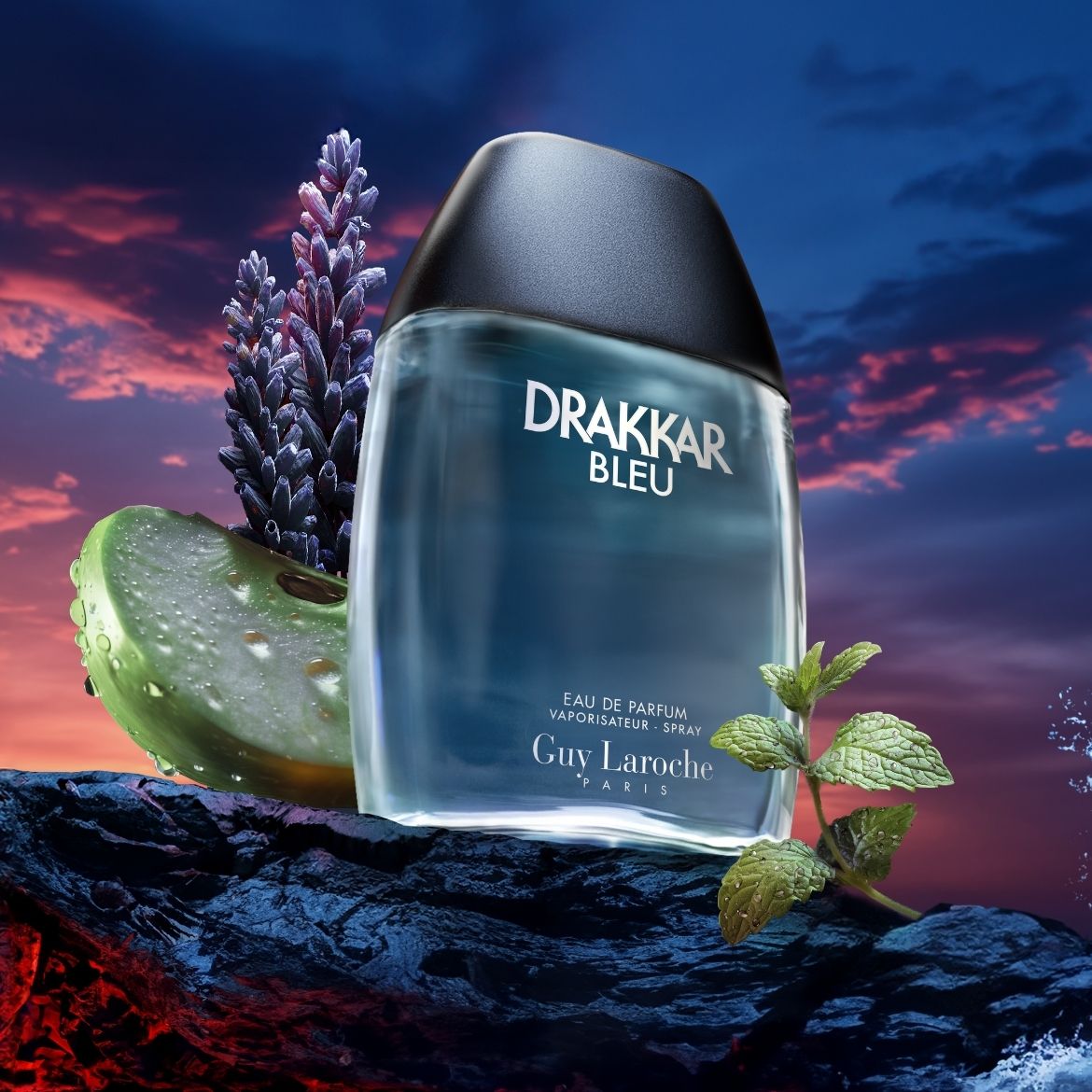 Le parfum Drakkar Bleu de Guy Laroche, un parfum aromatique fougère pour homme, présenté dans un flacon bleu transparent avec un bouchon noir, accompagné de lavande, de menthe et d'une tranche de pomme verte.