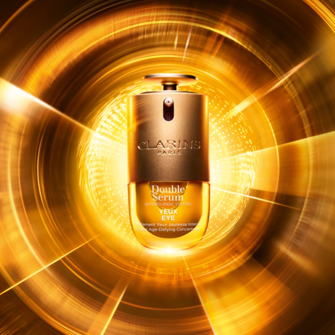 Le sérum double Clarins pour les yeux, un concentré défiant l'âge, est présenté dans un flacon doré avec un fond tourbillonnant de lumière dorée.