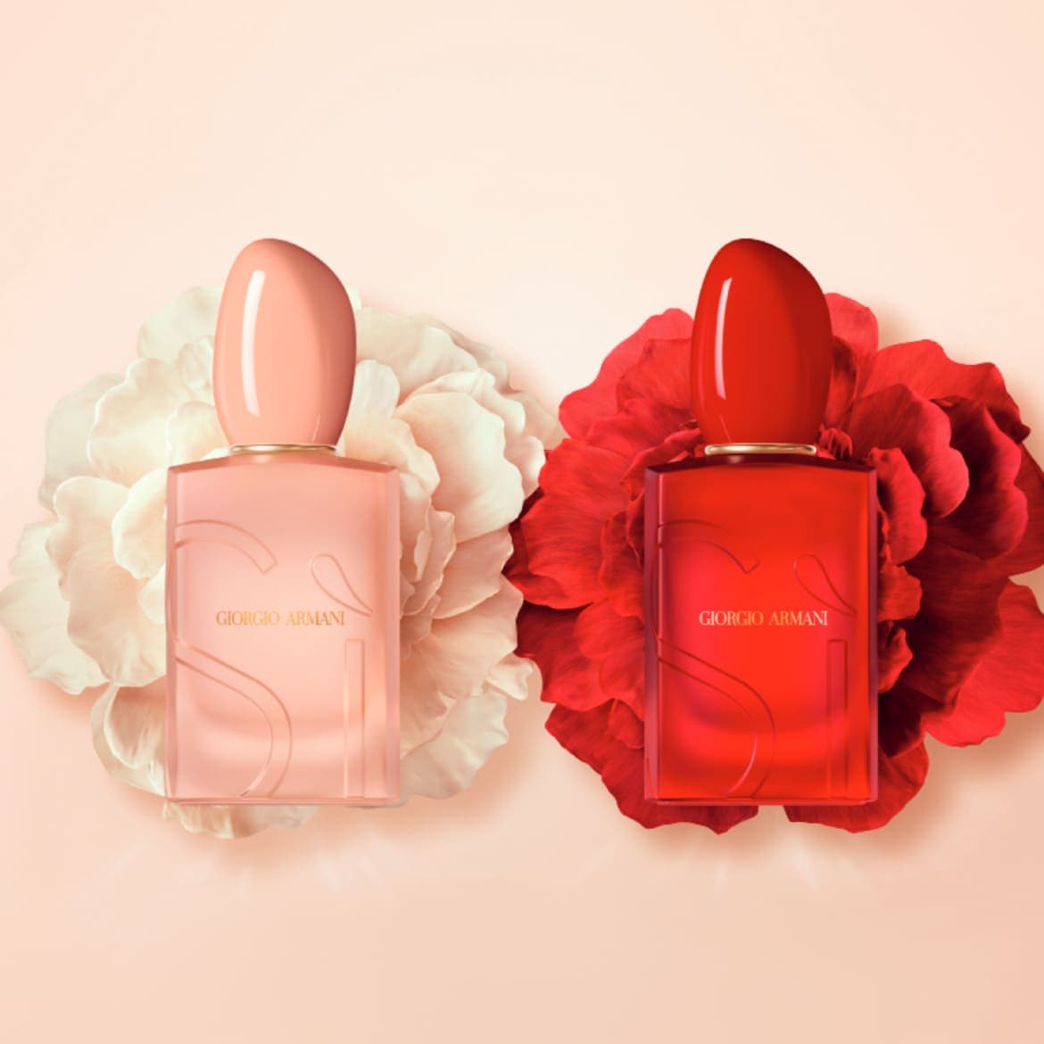 Deux flacons de parfum Giorgio Armani, l'un rose pêche et l'autre rouge vif, sont présentés sur des fleurs assorties, offrant une image élégante et parfumée.