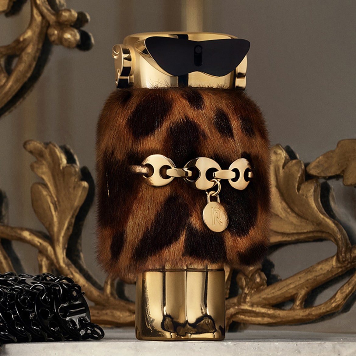 Admirez ce flacon de parfum Roberto Cavalli, orné d'un motif léopard et d'une chaîne dorée, un véritable bijou