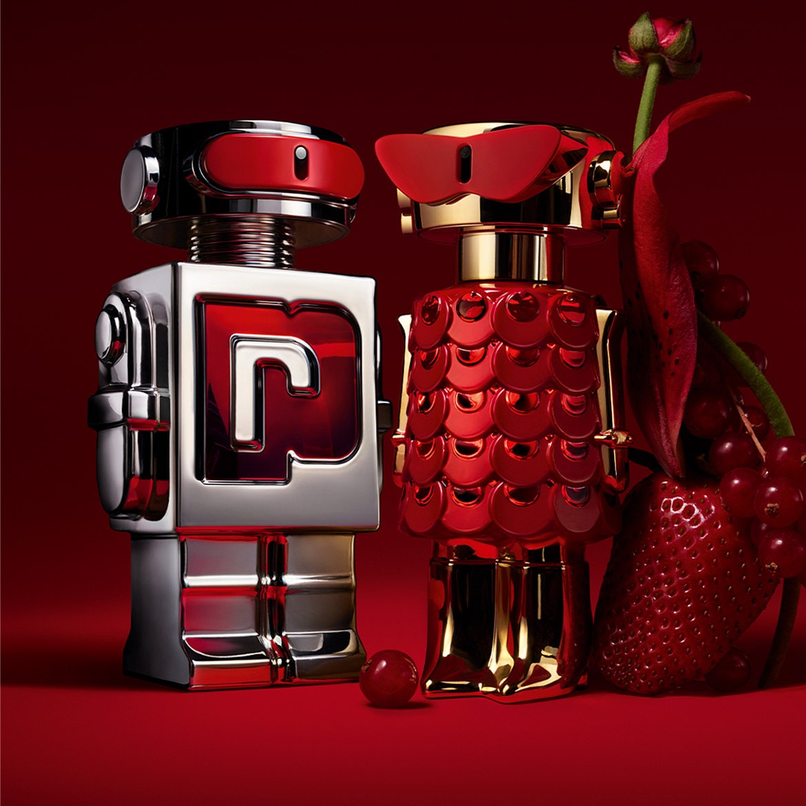 Découvrez le parfum Paco Rabanne dans des flacons robotiques argentés et dorés, présentés avec des fraises et des fleurs rouges sur fond rouge.