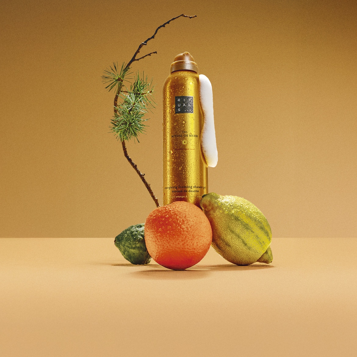 Découvrez le gel douche moussant énergisant Ritual of Mehr dans son flacon doré, accompagné d'une mousse onctueuse et d'arômes d'orange.