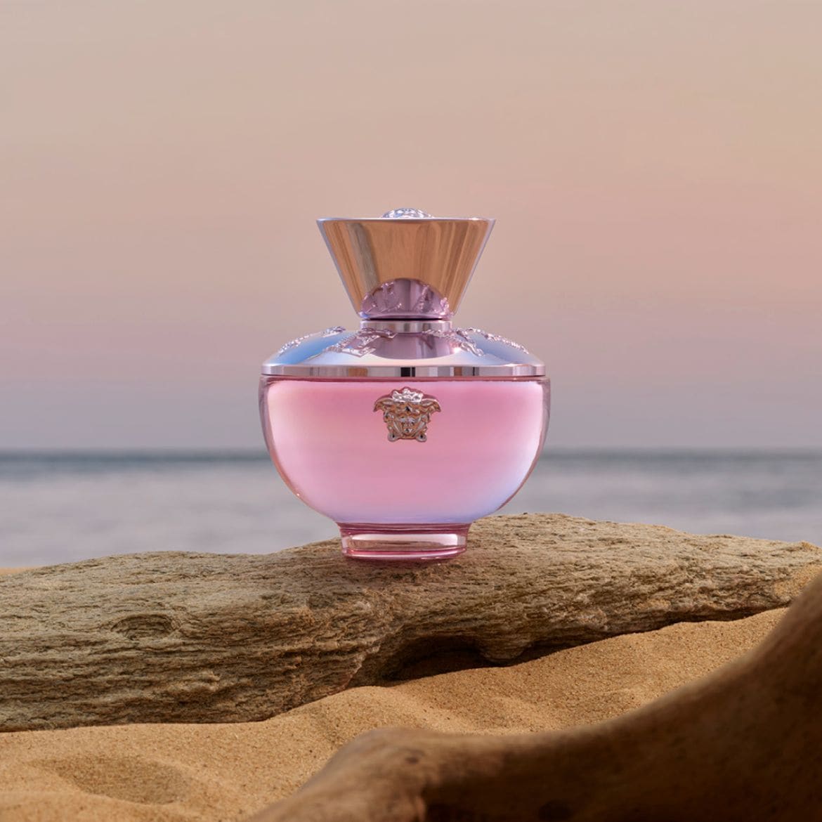 Découvrez le parfum Versace pour femme, présenté dans un flacon rose délicat orné du logo emblématique de la marque, évoquant une sensation de luxe et de féminité.