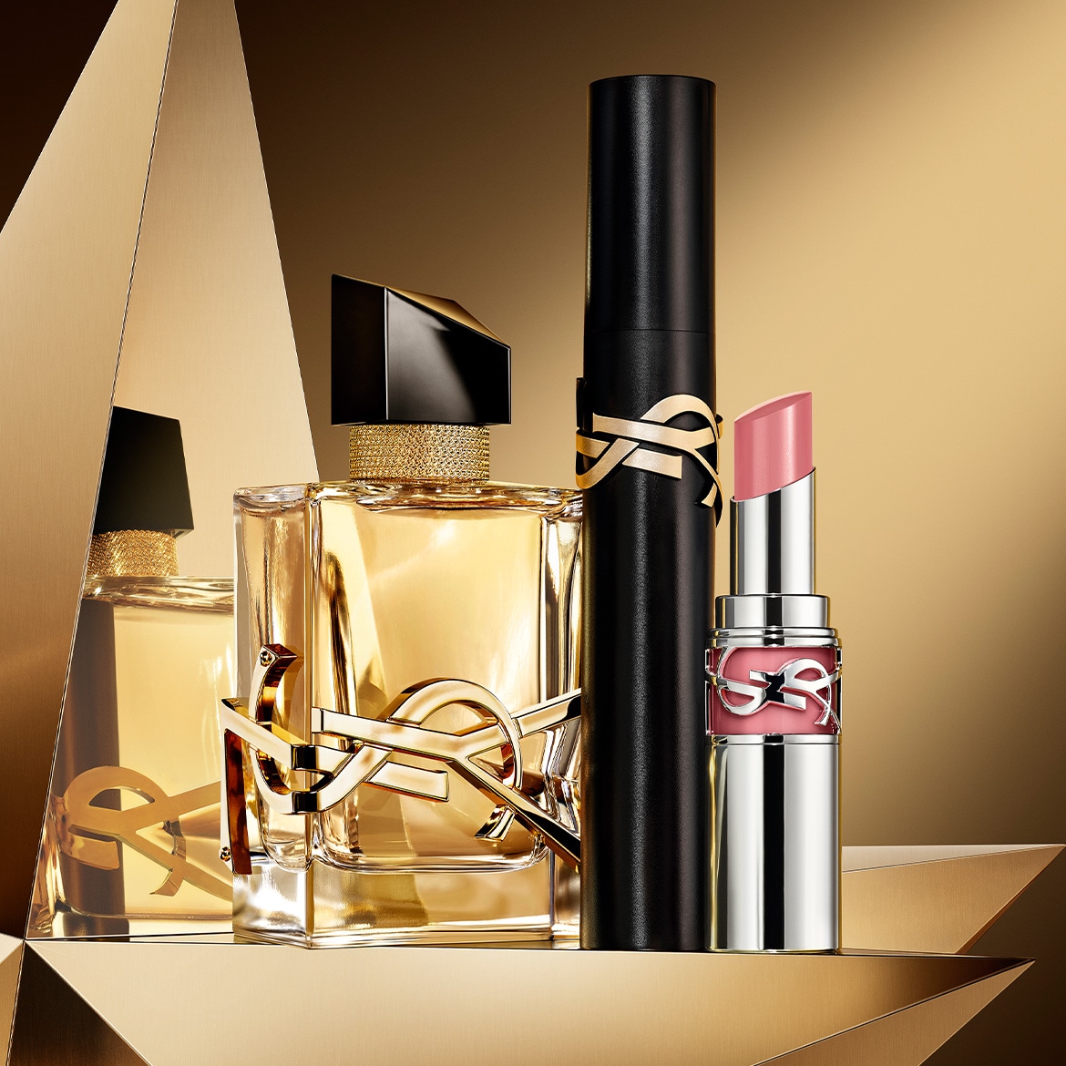 Découvrez un parfum ambré floral dans un flacon géométrique, un mascara noir intense et un rouge à lèvres rose brillant, le tout orné du logo YSL.