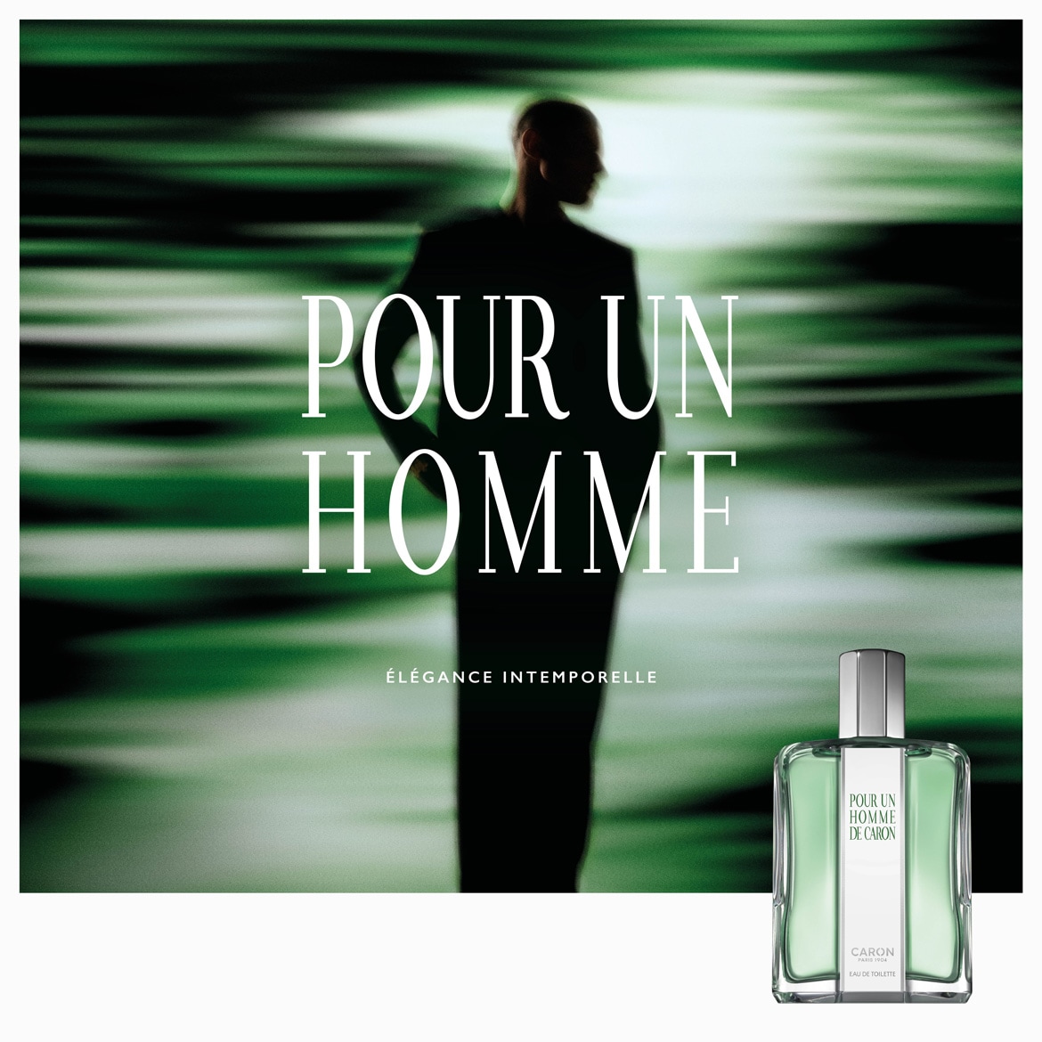 Un flacon de parfum Pour Un Homme de Caron, avec un liquide vert clair et un capuchon argenté, est présenté devant une silhouette masculine floue sur un fond vert abstrait, avec le texte "POUR UN HOMME ÉLÉGANCE INTEMPORELLE".