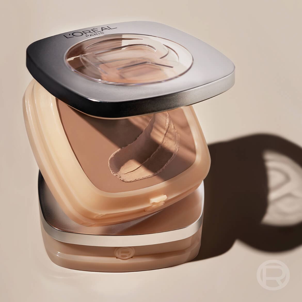 Le fond de teint L'Oréal Paris Infaillible 24H Fresh Wear en poudre est présenté ouvert, révélant sa texture crémeuse et sa teinte beige clair, avec le logo L'Oréal Paris visible sur le couvercle.