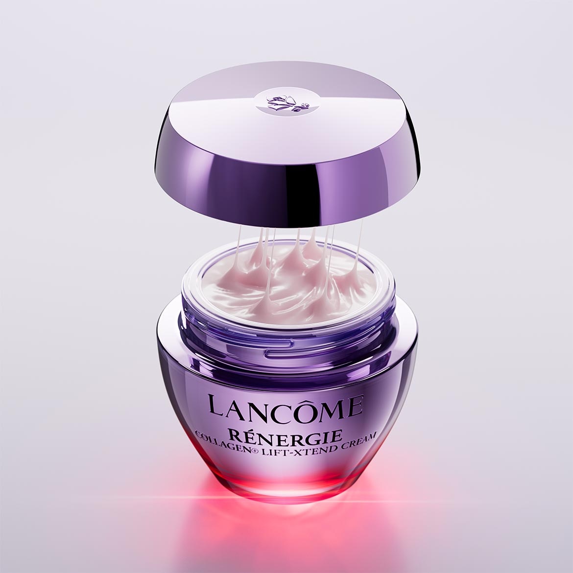 Découvrez le parfum Le Patchouli de Réminiscence, présenté dans un flacon rectangulaire ambré avec un bouchon noir, orné de fleurs violettes.