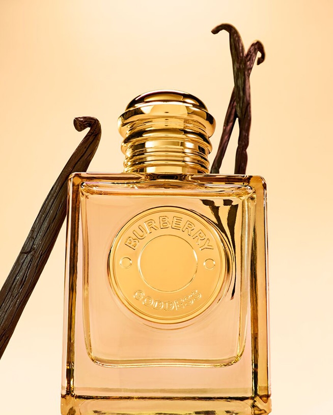 Découvrez le parfum Burberry Goddess dans son flacon carré doré, accompagné de gousses de vanille, pour une expérience olfactive divine.