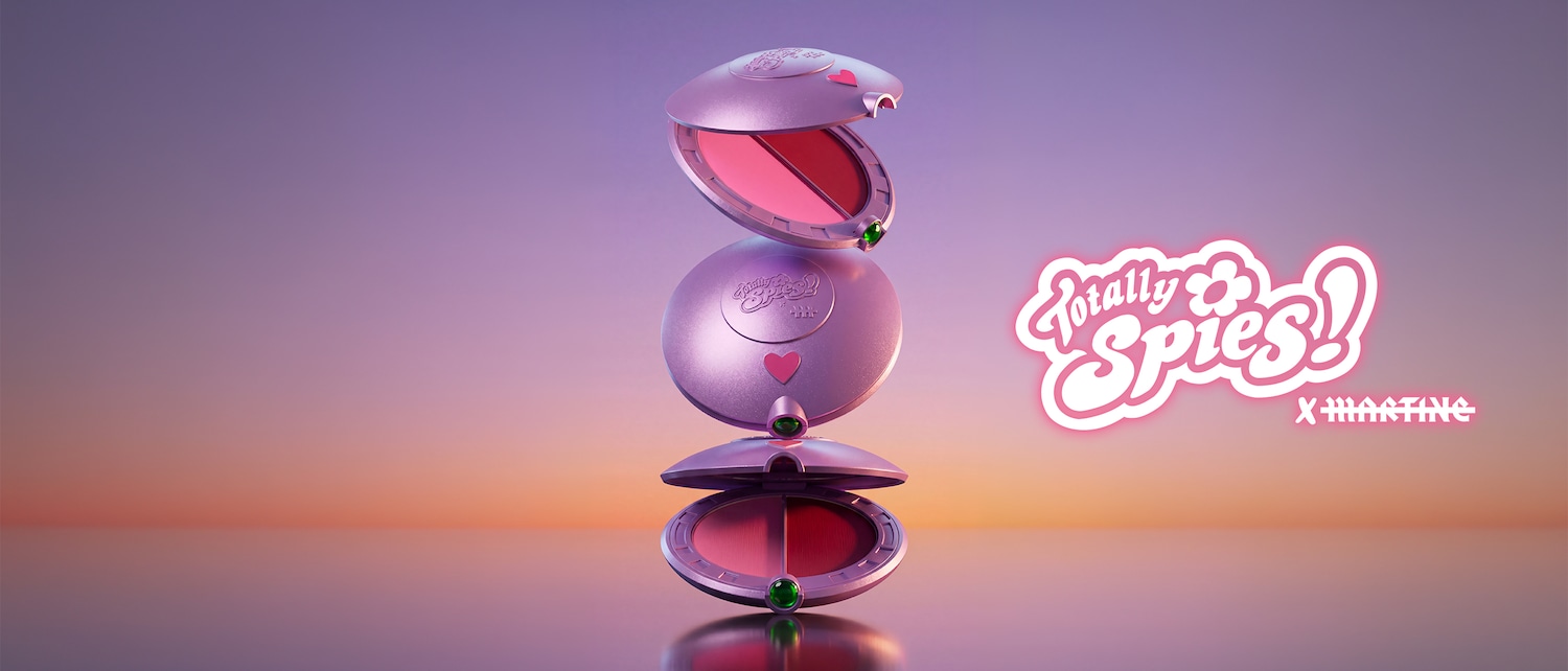 Trois poudriers ronds Totally Spies x Martine en édition limitée, de couleur lilas métallique, sont empilés verticalement sur un fond dégradé de violet et d'orange, avec le logo rose fluo "Totally Spies! x Martine" à droite.