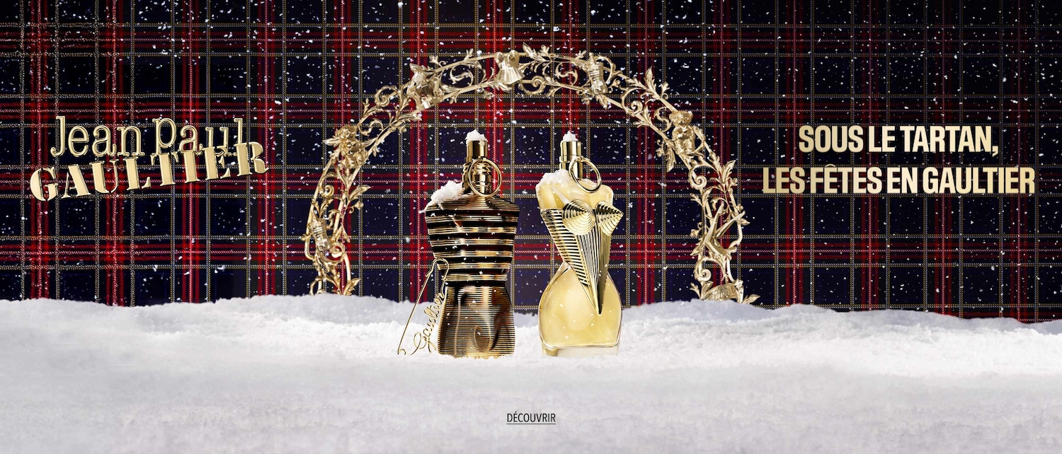 Découvrez les parfums Jean Paul Gaultier dans leurs flacons emblématiques en forme de buste, présentés sous un tartan festif et enneigé.
