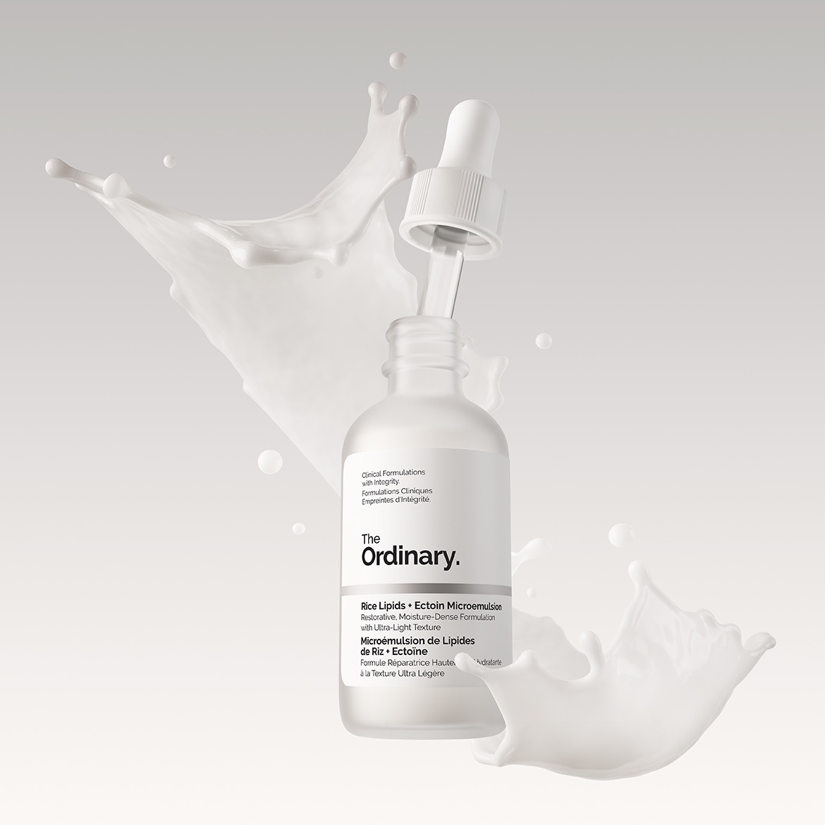 Découvrez le sérum The Ordinary Rice Lipids + Ectoin Microemulsion, une formule réparatrice haute à la texture ultra légère, présentée dans un flacon blanc minimaliste avec pipette, le tout éclaboussé de lait.