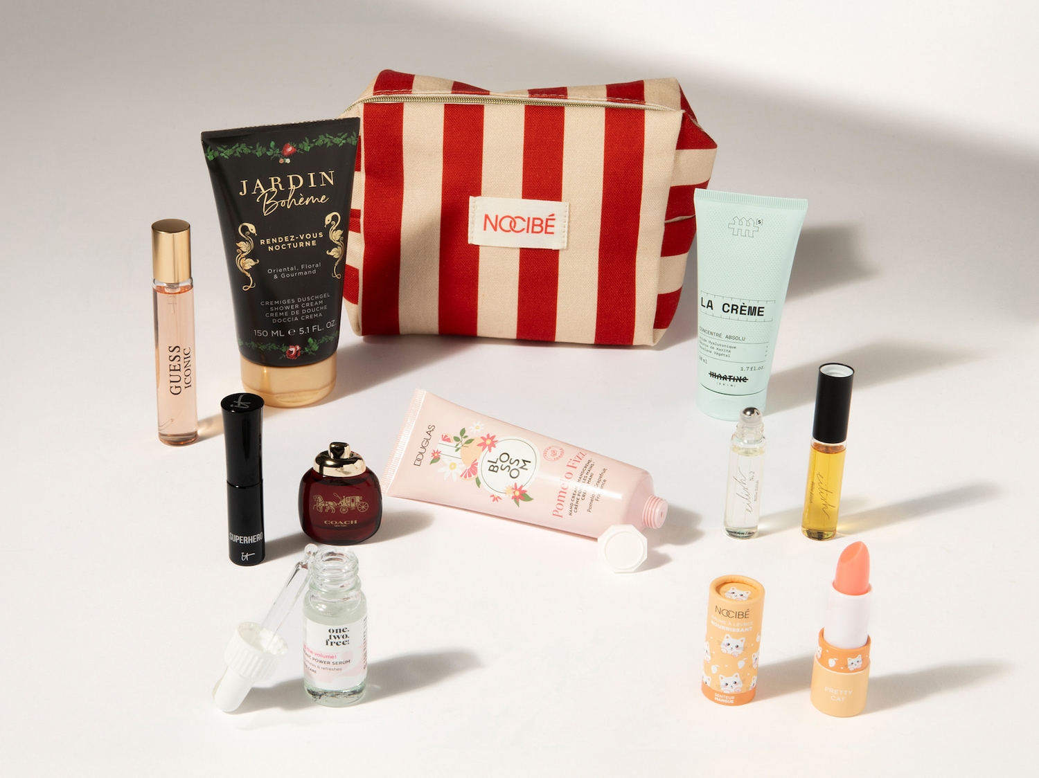 Découvrez un assortiment de produits de beauté, incluant des parfums comme Guess Iconic et Coach, des soins pour le corps Jardin Bohème, et des essentiels Nocibé, le tout présenté avec élégance.