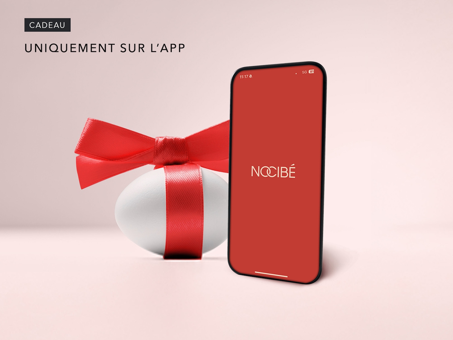 Découvrez un cadeau disponible en exclusivité sur l'application, représenté par un paquet cadeau blanc orné d'un ruban rouge, à côté d'un téléphone affichant le logo de l'application Nocibé sur un écran rouge.