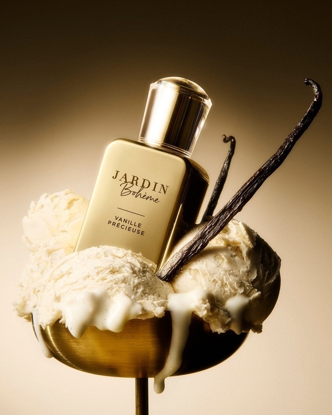 Flacon de parfum « Jardin Bohème – Vanille Précieuse » posé dans une coupe de glace à la vanille fondante, accompagné de gousses de vanille sur fond doré chaleureux — une illustration de parfums gourmands sucrés, crémeux et sensuels.