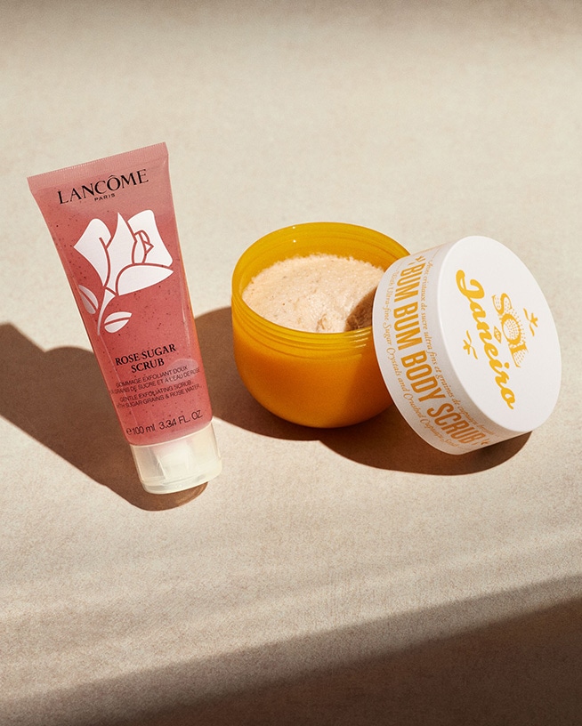 Découvrez le gommage au sucre rose de Lancôme dans un tube rose, et le gommage corporel Bum Bum de Sol de Janeiro dans un pot jaune.